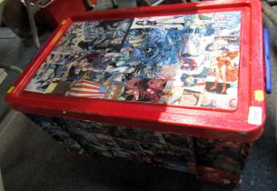 A toy chest/storage crate decorated with various comic book strip pictures.