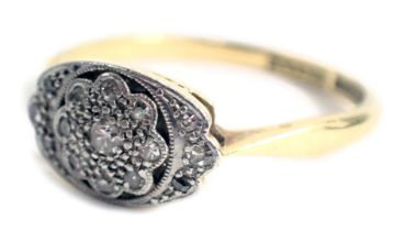 An Art Deco dress ring, the oval panel with central floral cluster, set with tiny diamonds, on a yel