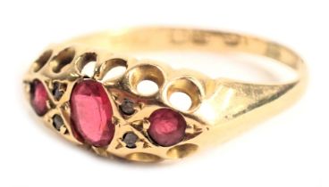 An 18ct gold gypsy ring, set with three oval cut rubies and four tiny diamonds, with pierced work bo