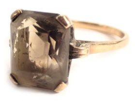 A 9ct gold dress ring, set with a rectangular cut smoky quartz, in four claw setting in a raised bas