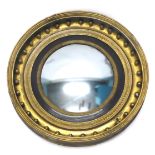 A Regency giltwood and gesso convex wall mirror, the moulded frame applied with spheres and with lea
