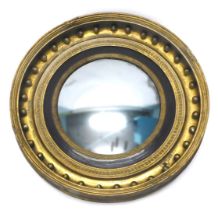 A Regency giltwood and gesso convex wall mirror, the moulded frame applied with spheres and with lea