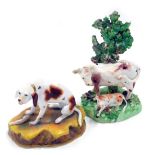 Two Staffordshire 19thC porcelain figures, to include a hound seated on a stylised mound, a bocage f