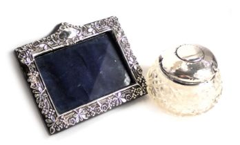 A cut glass dressing table jar, with hammered silver lid, and a part silver photograph frame. (AF)