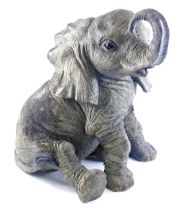 A resin model of a seated elephant, with grey mottled finish, 54cm high.