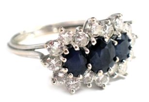 An 18ct white gold sapphire and diamond dress ring, set with three oval sapphires, of graduated desi