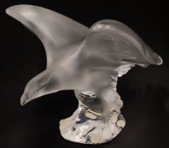 A Lalique part frosted model of an eagle, label to reverse, and serial number 1205700, 19cm long.