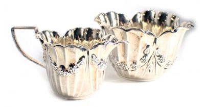 A late Victorian silver sugar bowl, embossed with swags of flowers, etc., and a matching sugar bowl,