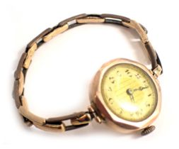 A 9ct gold wristwatch, with an octagonal framed and circular watch head, on a silvered numeric dial,