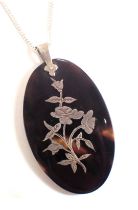 A pendant and chain, the pendant of oval design inlaid with white metal flower, 5cm high,