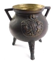 A heavy bronze two handled cauldron, cast with putti, etc., three tapering feet decorated with masks