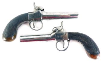 A pair of early 19thC pistols, each with a polished barrel, partly engraved and walnut stock, 19cm l