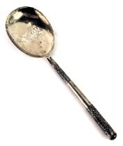 An eastern white metal serving spoon, with scroll design handle, white metal stamped SS, with weight