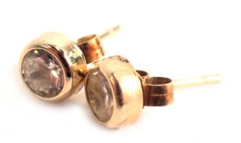 A pair of diamond stud earrings, each with stone approx 0.18ct, in a rub over setting on single pin