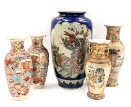 A pair of Japanese earthenware vases, each decorated with figures and with raised enamels, and vario