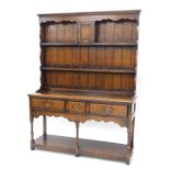 A Titchmarsh & Goodwin oak dresser in 18thC style, the raised back with panelled door, and two shelv