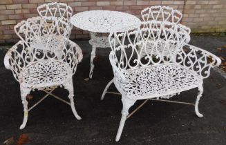 A cream painted cast metal garden table, with pierced decoration, 80cm diameter, matching sofa and t