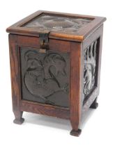 An early 20thC Arts and Crafts oak coal skuttle or box, applied with panels with hammered copper pan