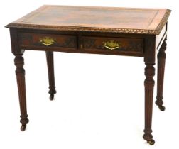 A late 19thC carved oak writing table, with a brown and gilt leather inset, and a leaf carved border