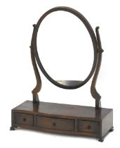 A mahogany dressing table mirror in George III style, with oval plate on shaped supports, the serpen