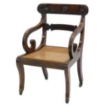 A Regency mahogany open armchair, the bar back carved with roundels and scrolls, with reeded shaped