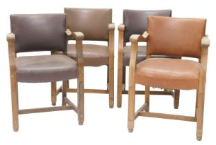 A set of four early 20thC oak open armchairs, each with a brown leatherette padded seat, within stud