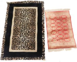 A modern leopard print machine woven rug, with black borders, on a cream ground, 107cm wide, 164cm t