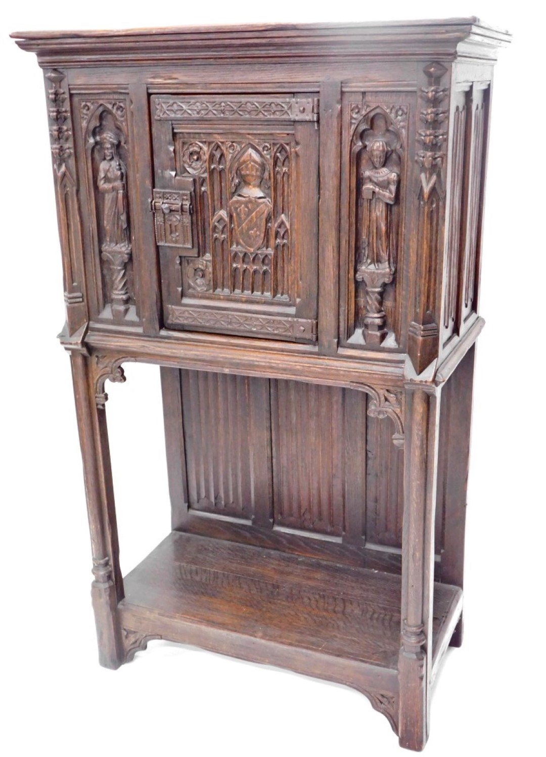 A 19thC oak carved Gothic cabinet, the rectangular top above a carved and frieze door, with two figu