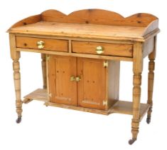 A late Victorian pine washstand, with a raised back above two frieze drawers and two cupboard doors,