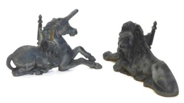 A pair of large cast iron fire dogs, modelled in the form of a recumbent lion and a recumbent unicor