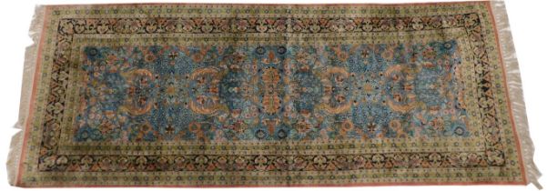 A Persian silk runner, with all over floral and leaf design, on a blue ground with multiple borders,