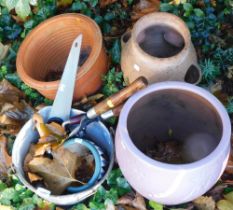 A herb pot, terracotta plant pot, small group of tools, preserve pan, and a purple glazed planter.