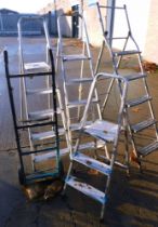 Four step ladders and a sack truck.