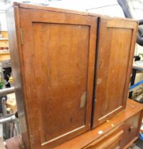 A stained pine two door cupboard.