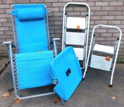 Two white folding step ladders, and a garden lounger.