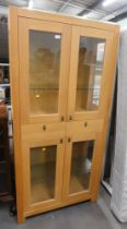 A beech finish modern display cabinet, with arrangement of four glazed doors and two drawers.