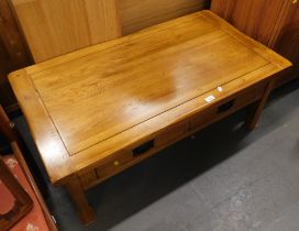 An oak low rectangular coffee table with two drawers.