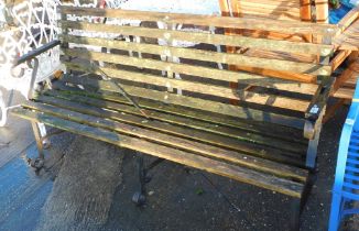 A wrought iron and wood slatted garden bench, with arched and scroll metal supports, with curved bac