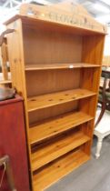 A pine bookcase, with arched top and clover leaf design.
