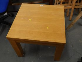 An beech effect square coffee table, with chrome supports.