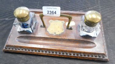 A 19thC oak desk stand, with reeded border and brass shield, and two glass inkwells, 24cm wide.