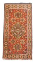 A Caucasian red ground rug, decorated with a large central medallion, two smaller medallions and fou