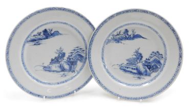 A pair of Qianlong porcelain blue and white plates, decorated with river landscapes, within hatched