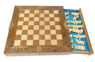 A Chinese carved boxed chess set, of hinged form, opening to reveal a chess board top, with two side