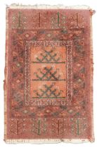 A Caucasian red ground rug, decorated with trees within floral borders, 85cm x 52cm.