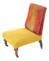 A Victorian mahogany nursing chair, upholstered in contrasting seat and back, raised on turned legs,