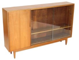 A MacIntosh teak sideboard, with a single door opening to reveal a shelf, aside a pair of glass slid