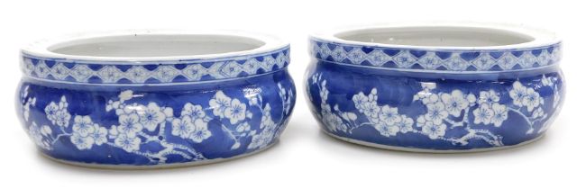 A pair of Chinese blue and white porcelain urn stands, or bowls, decorated with prunus blossom on a