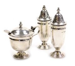 An Elizabeth II silver three piece condiment set, comprising salt, pepperette and mustard pot, no li