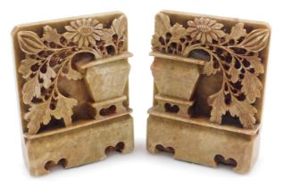 A pair of Chinese soapstone bookends, each carved as a vase of flowers on a plinth base, 14cm high.